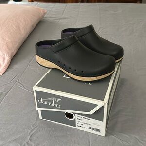 Dansko Kane molded black clogs.